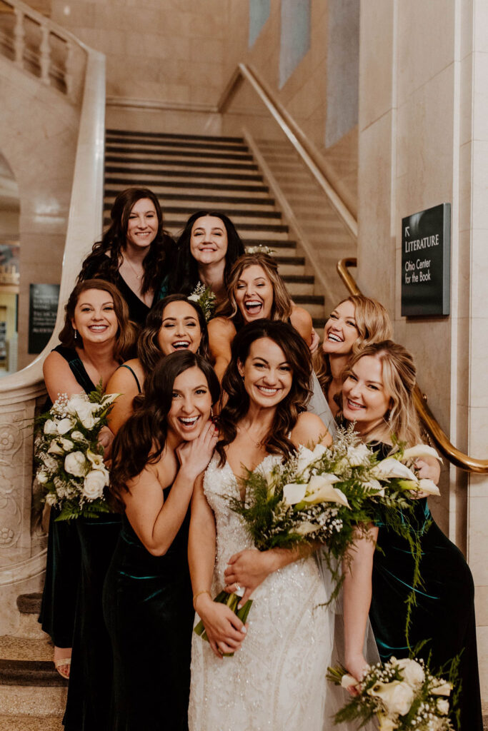 bridal party posing with bride on the stairs in a church