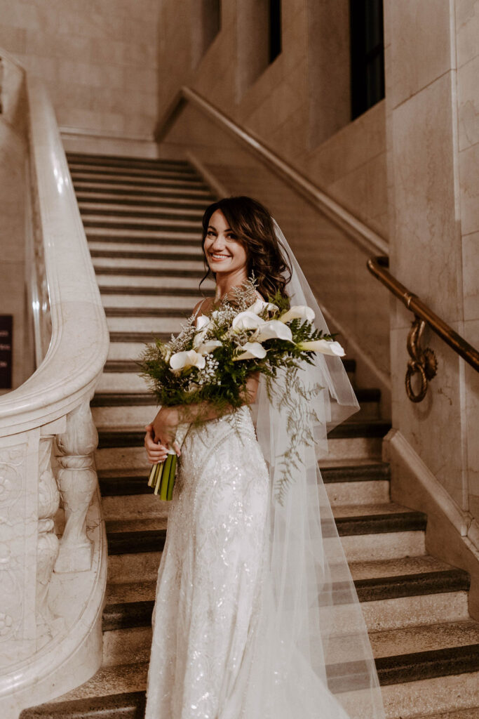 bride posing on stairs after her wedding reception