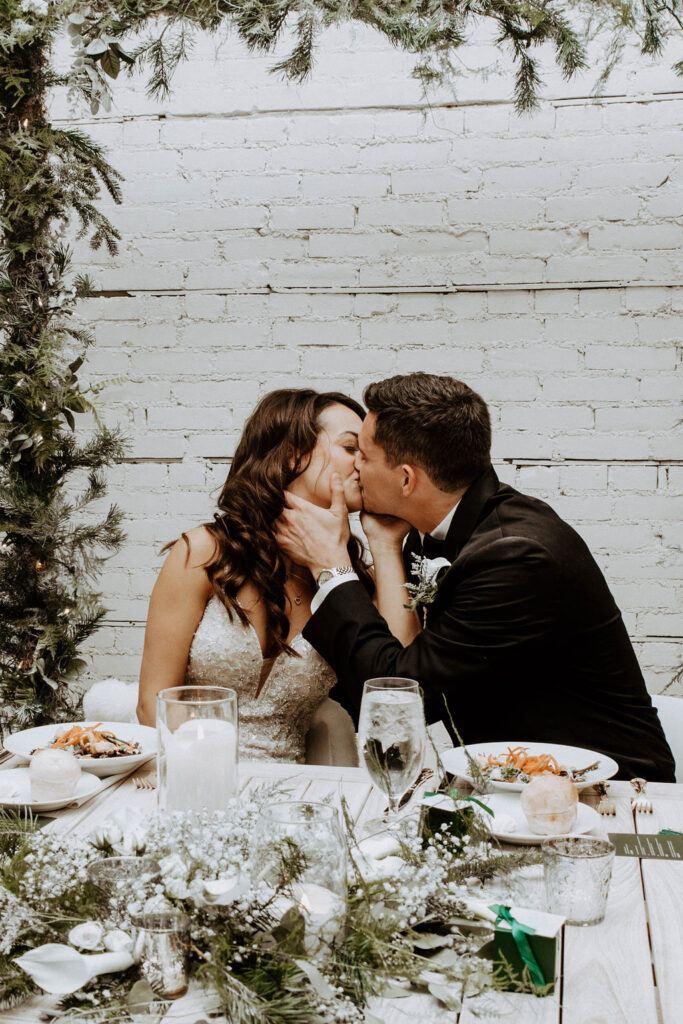 bride and groom kissing during their wedding reception