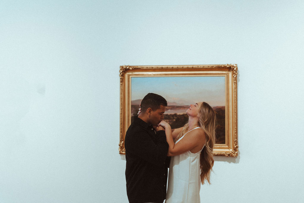 a photo of a couple posing in front of art at an art gallery in orlando