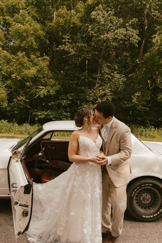 couple posing with a vintage car after their wedding day