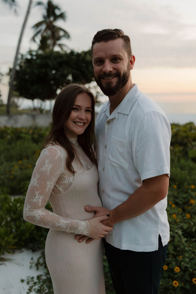 couple hugging and posing at the camera during their baby announcement photoshoot