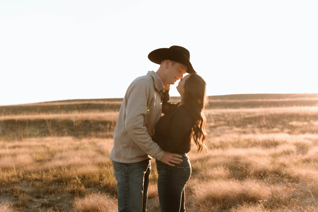 couple looking at each other during sunset at their country western engagement session