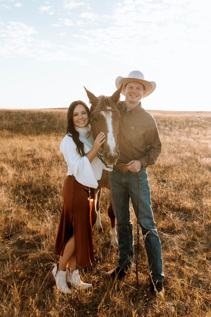 couple with their horse looking at the camera during their engagement session 
